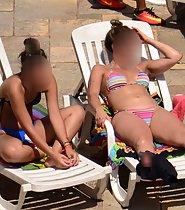 Hot teens sunbathing by swimming pool
