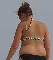 Chubby girl walks on beach