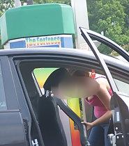 Busty girl leans inside car