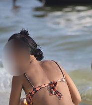 Wet girl bends over at the beach
