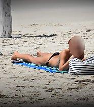 Redhead fixes bikini top on beach - Voyeur Videos
