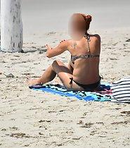 Redhead fixes bikini top on beach - Voyeur Videos