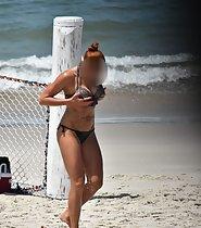 Redhead fixes bikini top on beach
