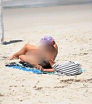 Redhead fixes bikini top on beach