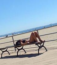 Amazing girl sunbathes on a bench