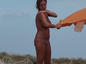 Curvy nudist woman rubs sunscreen all over herself Picture 2