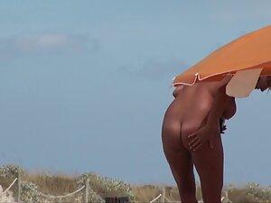 Curvy nudist woman rubs sunscreen all over herself Picture 7