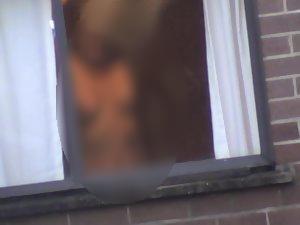 Mature woman changes by the window Picture 2