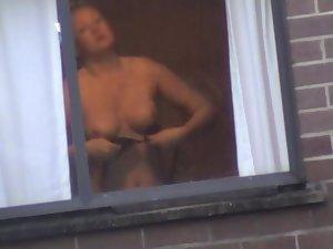 Mature woman changes by the window Picture 5