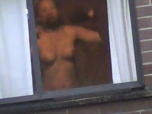 Mature woman changes by the window
