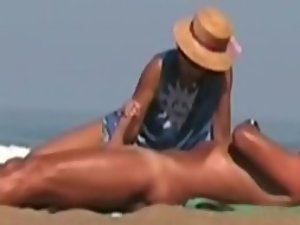 Hot lady gives a handjob at a beach