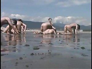 Bunch of nudists exercising on the beach Picture 4