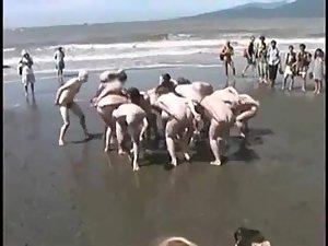 Bunch of nudists exercising on the beach Picture 6