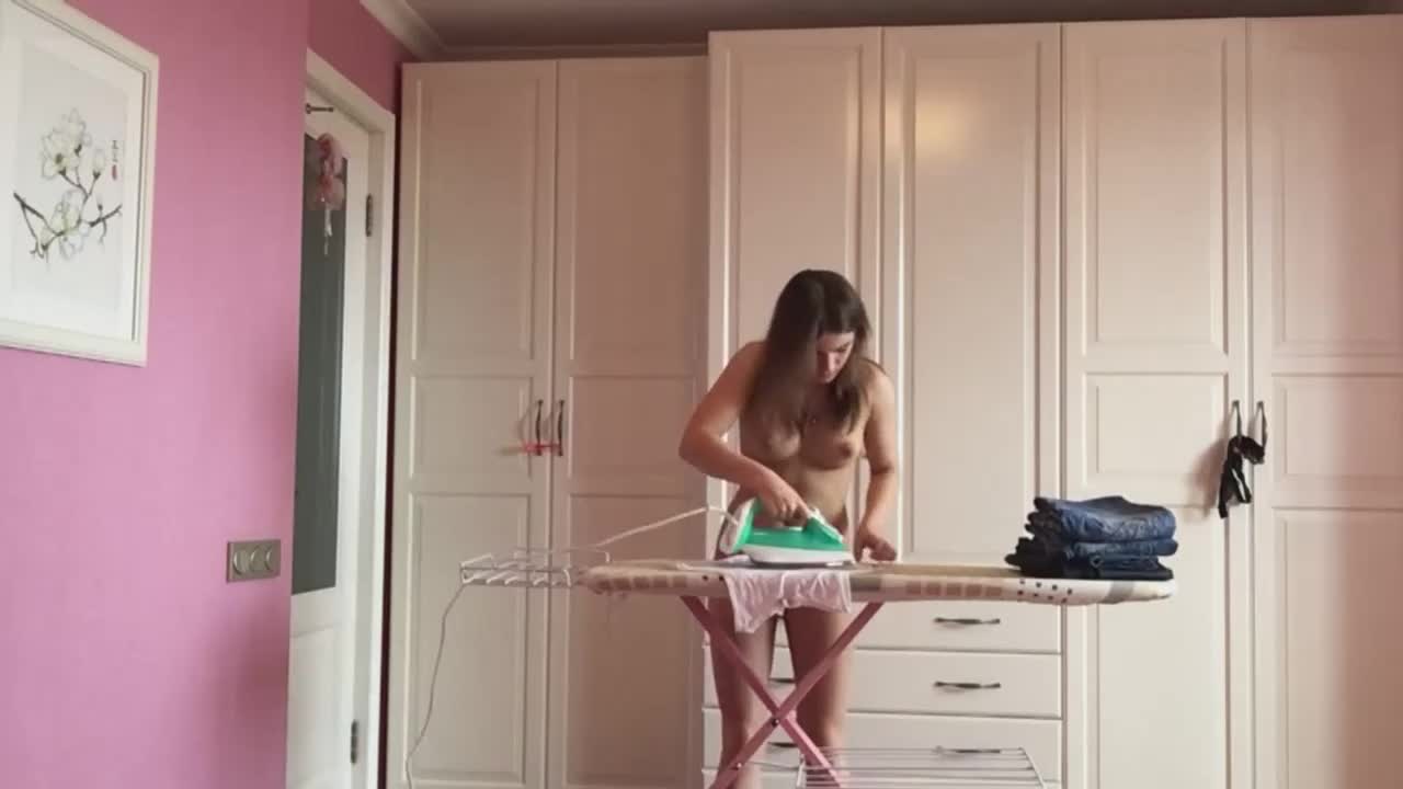 Naked wife ironing clothes at home