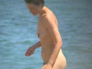 Mature nudist woman on the beach Picture 8