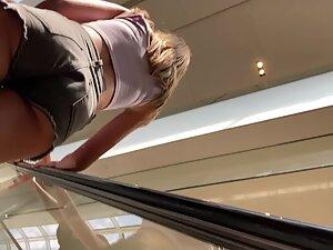 Sexy figure and tight booty in shorts on escalator