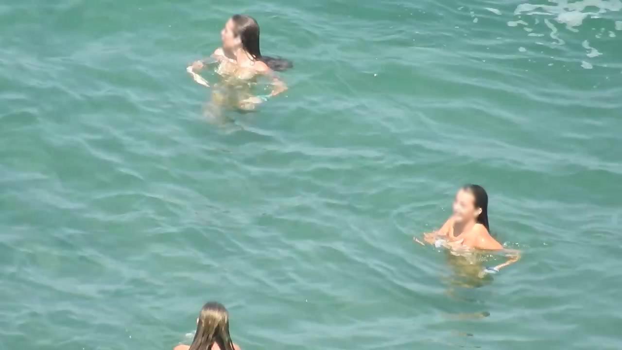 Teen nudist trio enjoying the water waves