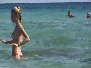 Thin topless woman smiles on a beach Picture 6