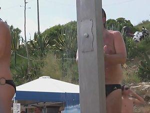 Naked woman with tattoos at beach shower Picture 1