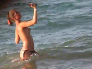 Sexy topless girl playing at the beach Picture 3