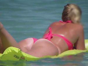Pale buttocks in a pink thong bikini