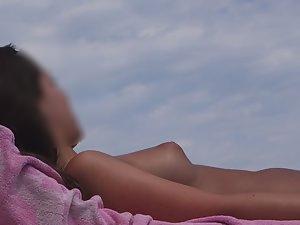 Topless girl texts and sunbathes Picture 1