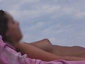 Topless girl texts and sunbathes Picture 2