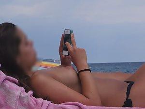 Topless girl texts and sunbathes Picture 3