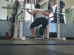 Fit girl squats in the gym