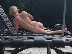 Peeping on astonishing blonde suntanning by the pool