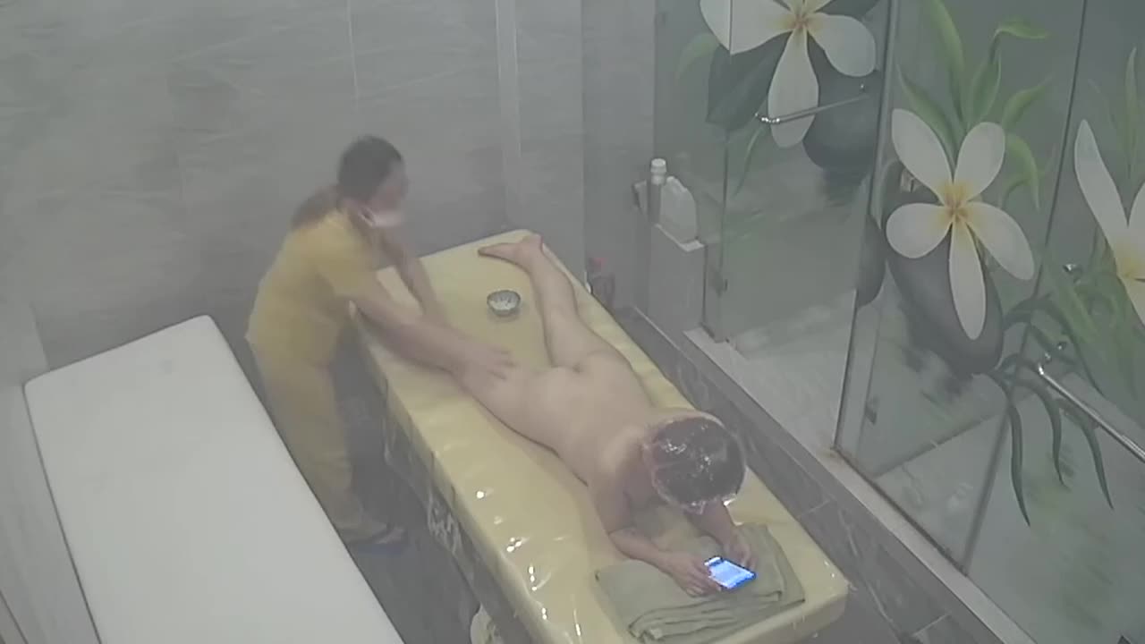 Naked woman is on her phone during entire massage