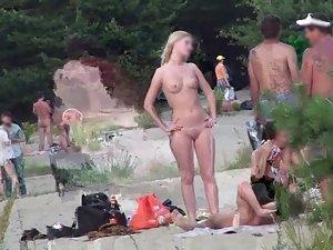 Nudist blonde and her friend getting attention on naked beach Picture 1