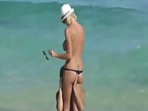 Skinny topless girl enters the water