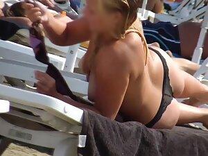 Voyeur keeps an eye on thick topless blonde at beach Picture 5