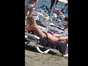 Voyeur keeps an eye on thick topless blonde at beach Picture 8