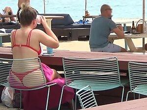 Bubble butt in red bikini is visible through the chair on the beach Picture 3