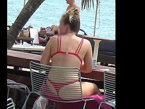 Bubble butt in red bikini is visible through the chair on the beach Picture 4