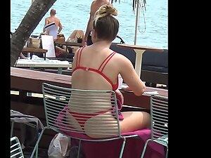 Bubble butt in red bikini is visible through the chair on the beach Picture 5