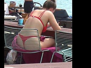 Bubble butt in red bikini is visible through the chair on the beach Picture 7
