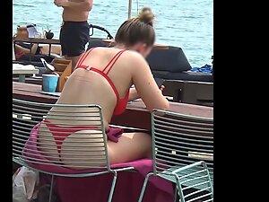 Bubble butt in red bikini is visible through the chair on the beach Picture 8