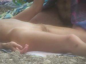 Nudist girl gets massage on beach Picture 1
