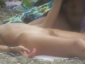 Nudist girl gets massage on beach Picture 2