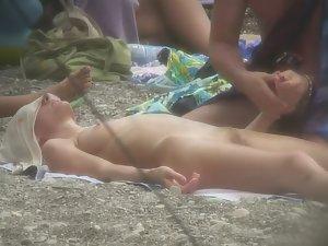 Nudist girl gets massage on beach Picture 3