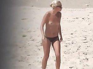 Topless beach babe in a thong bikini