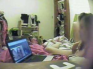 Asian girl watches porn and rubs pussy
