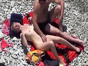 He is trying to finger her on a beach
