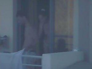 Quick glance of a topless girl on balcony