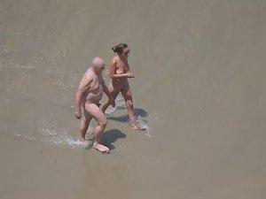 Zooming on weird nudist couple on beach Picture 1
