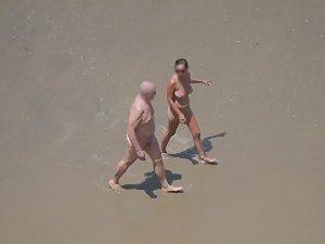 Zooming on weird nudist couple on beach Picture 3