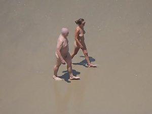 Zooming on weird nudist couple on beach Picture 4